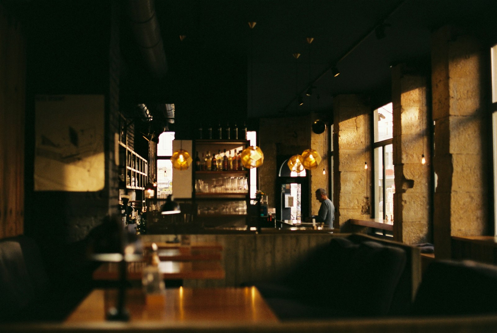 The warm, low-lit interior of UMAMI, looking down the hinoki-wood sushi counter